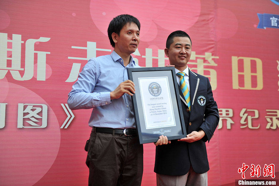 圖為世界吉尼斯認證官為鄭春輝(左)頒發(fā)證書。呂明 攝 圖為世界吉尼斯認證官為鄭春輝(左)頒發(fā)證書。呂明 攝