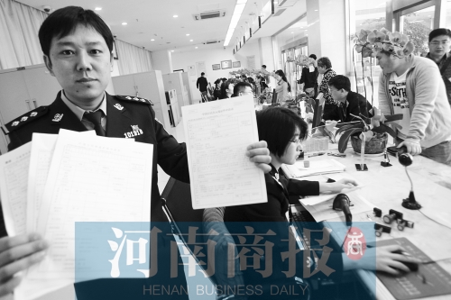 　民警左手拿的是新申請表，右手拿的是三份老申請表 王春勝/攝