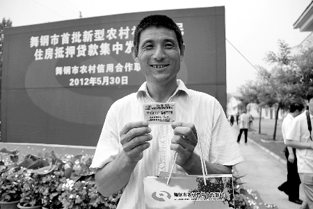 領(lǐng)到貸款，農(nóng)民開心地笑了。