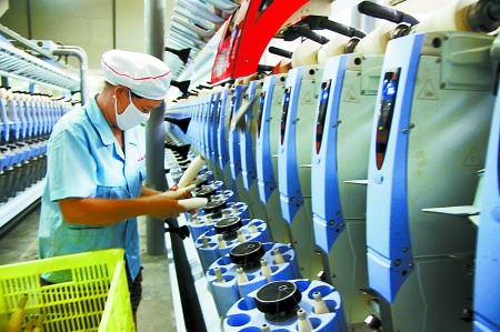 7月3日，在鄧州市永泰棉紡有限公司電腦控制全自動紡紗車間，紡織工人正在生產棉紗。