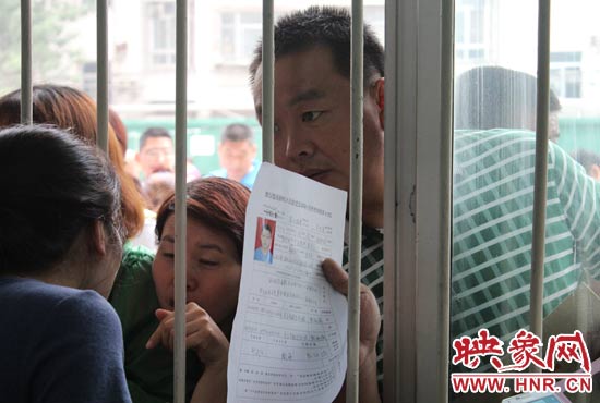 不少家長擠在報名窗口前咨詢報名事宜。