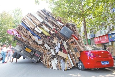紅色小轎車被砸，卡在路邊動(dòng)彈不得。