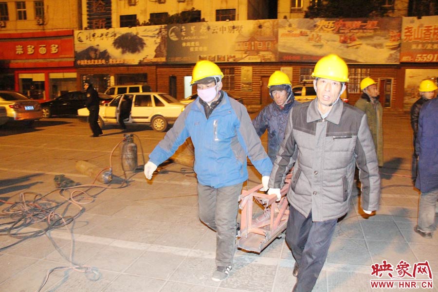 23點(diǎn)56分，第一塊兒廣告牌已經(jīng)分割完畢，地面上的20多名工人將拆除下來(lái)的鋼件撞車運(yùn)走。