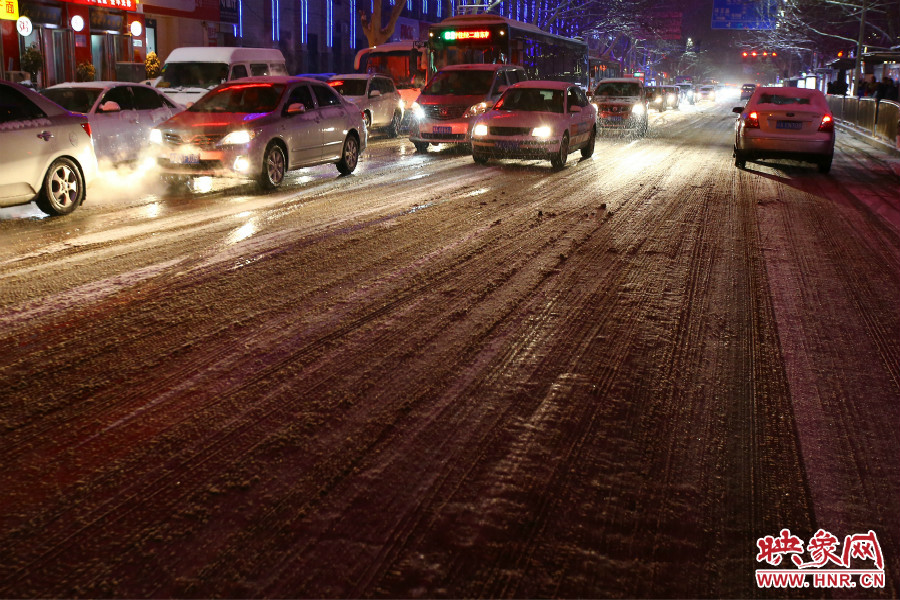 夜晚的雪路給出行的人們增加了困難。