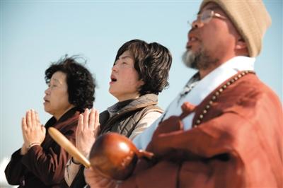 23日，一名僧侶引領(lǐng)人們?yōu)樗勒咂矶\。