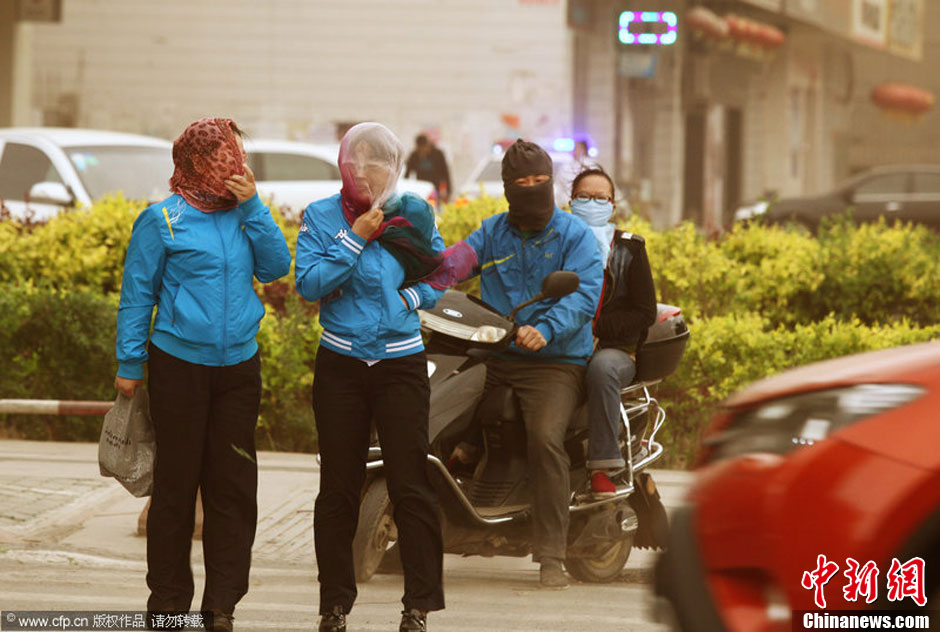 2014年04月23日，新疆維吾爾自治區(qū)吐魯番地區(qū)，市民戴著口罩行走在大風(fēng)沙塵中的吐魯番市街頭。