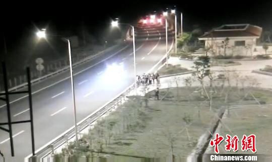 看到車輛經(jīng)過，孩子們便急忙跑到一旁的花圃上?！【焦﹫D　攝