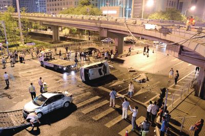 路虎沖下國(guó)貿(mào)橋砸中一輛起亞轎車，橋上厚達(dá)幾十厘米的水泥護(hù)欄被撞斷，碎石四處散落，數(shù)十群眾在現(xiàn)場(chǎng)圍觀。