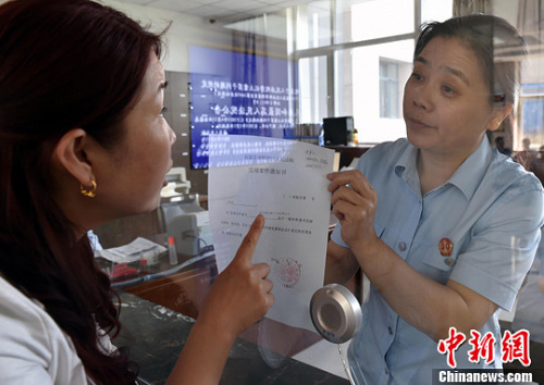 資料圖：2015年5月4日，河北石家莊市橋西區(qū)人民法院立案庭庭長齊燕正在為立案人辦理相關(guān)手續(xù)，完成整個過程只用了5分鐘。當(dāng)日是立案登記制改革首個工作日，該院共立案36件，立案率達到90%。中新社發(fā) 翟羽佳 攝