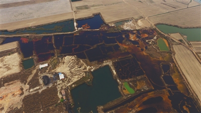 4月19日，廊坊市大城縣南趙扶鎮(zhèn)，津保路以北約八九百米處，一個巨大的污水坑中，水體呈現(xiàn)紅褐色。 新京報記者 尹亞飛 攝