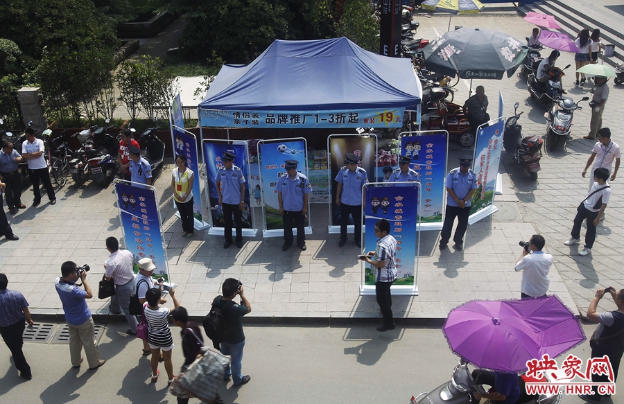 執(zhí)法人員用宣傳牌圍擋占道經(jīng)營攤位。