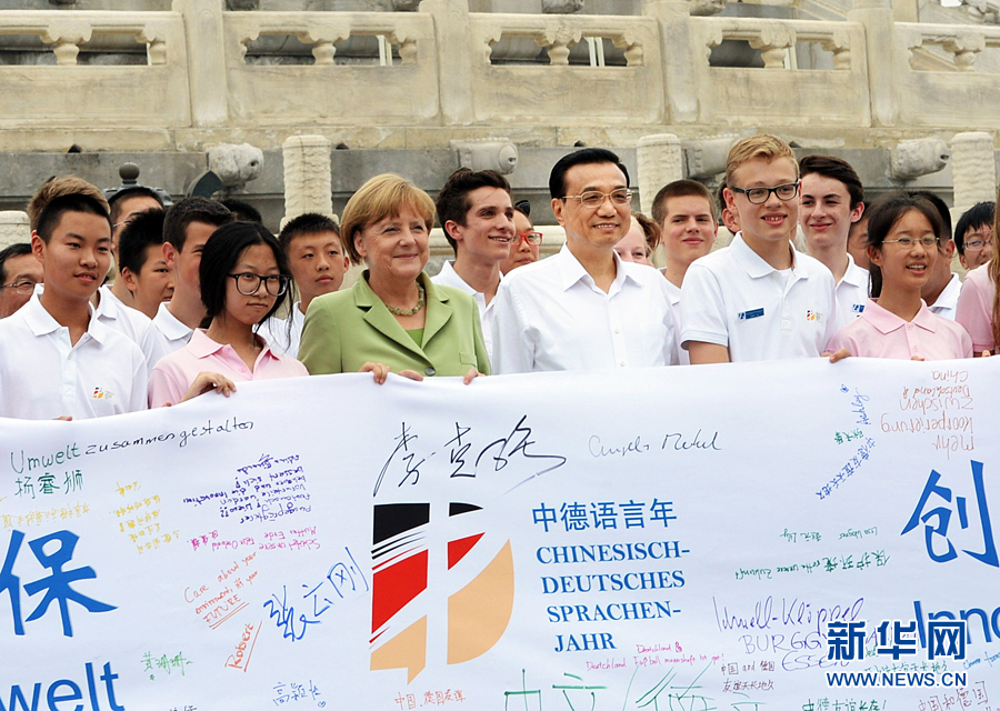李克強(qiáng)同默克爾與青少年在天壇祈年殿前合影留念。