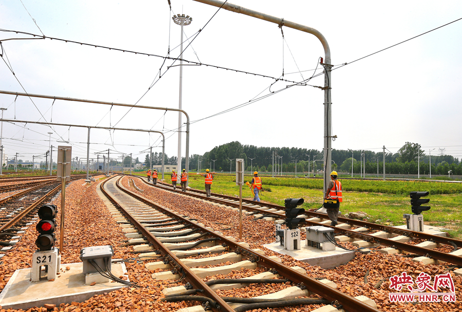 在太陽的直射下，檢修工人扛著沉重的設(shè)備向施工地點(diǎn)出發(fā)