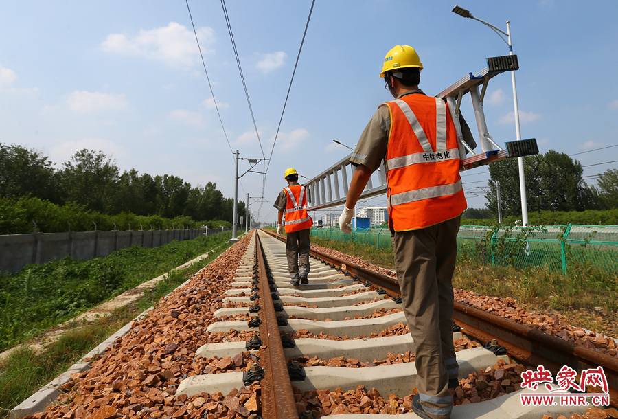 滾燙的鐵軌上，兩個(gè)扛著梯子的檢修員走向第四個(gè)檢修點(diǎn)