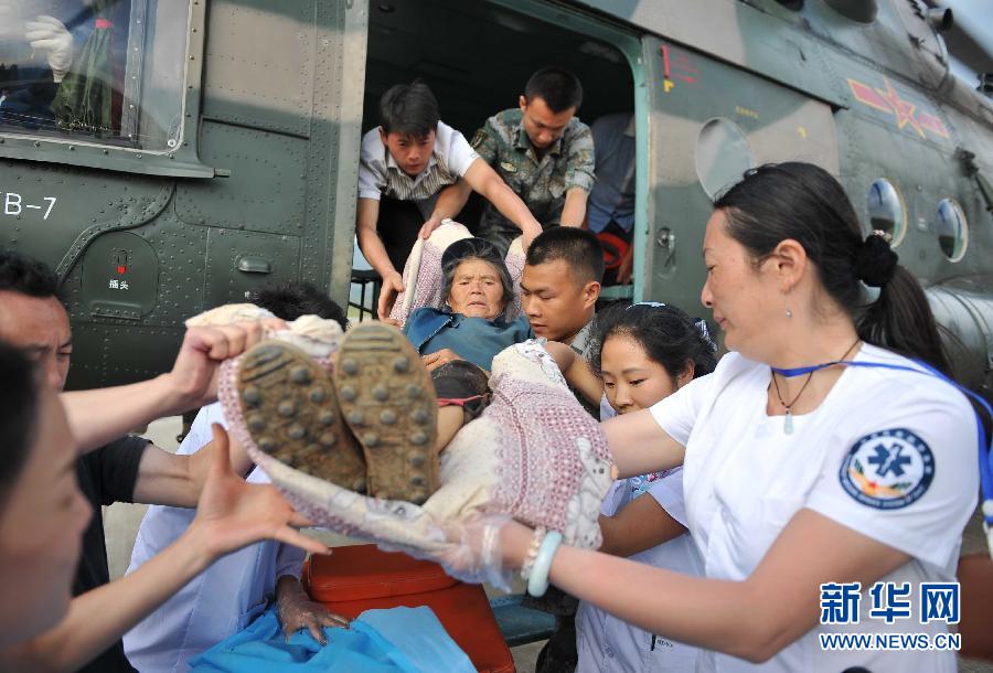 8月5日，醫(yī)護人員將一名通過直升機從震中轉(zhuǎn)運出來的傷員運下飛機。