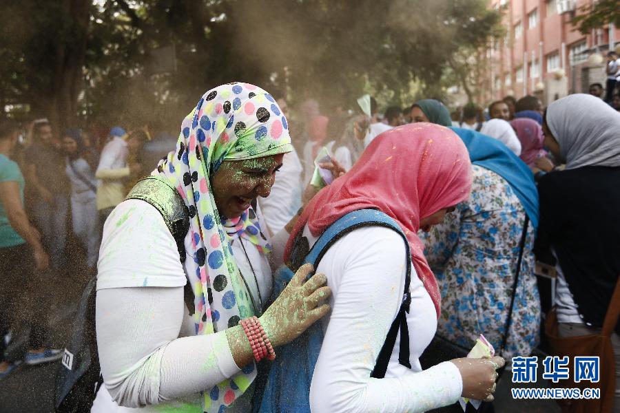 10月16日，在埃及首都開羅，兩名女青年在“彩色跑”活動(dòng)中躲避人們拋撒的彩色粉末。