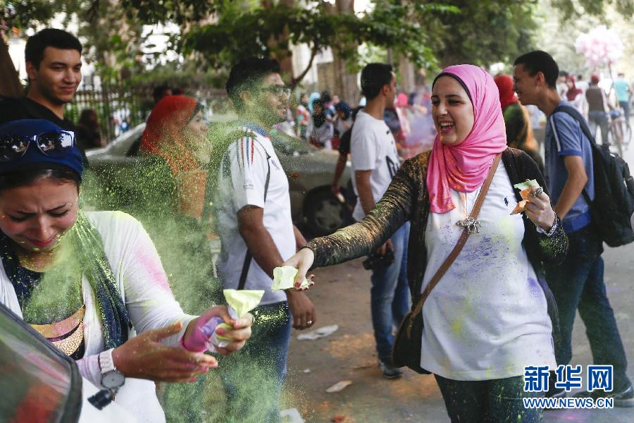 10月16日，在埃及首都開羅，一名女青年在“彩色跑”活動(dòng)中拋撒彩色粉末。