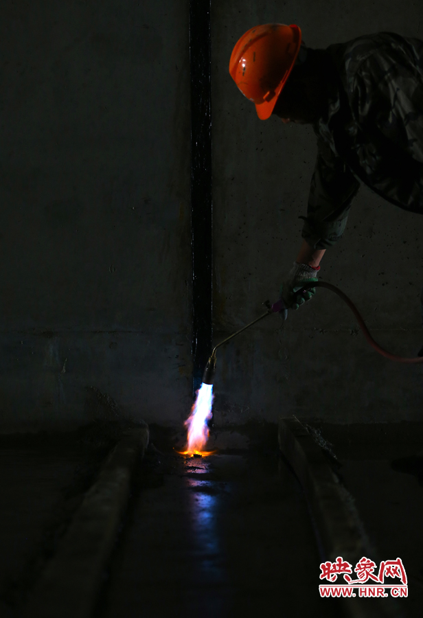 工人師傅用噴槍烘干地面，便于做防水處理