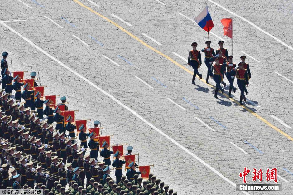圖為俄羅斯國(guó)旗從受閱部隊(duì)前經(jīng)過(guò)。