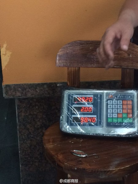 父子倆為大魚(yú)量體重。