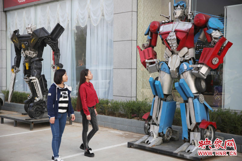 10月14日，市民在參觀河南省平頂山市寶豐縣一家企業(yè)門前的“變形金剛”。