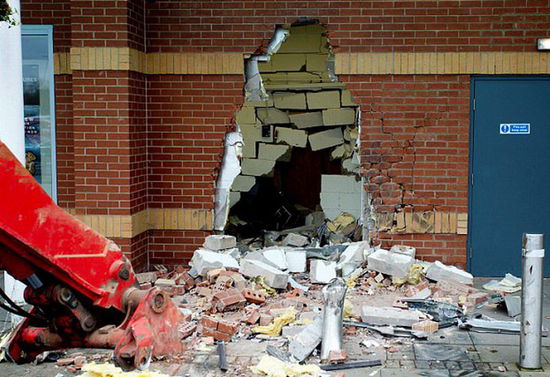 劫匪利用挖掘機(jī)的機(jī)械臂移走ATM機(jī)，留下滿地狼藉