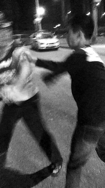 一名男子扯著民警的反光背心一路追打。