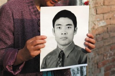 5月19日，朝陽北路，母親捧著張東文的遺像。新京報記者 侯少卿 攝