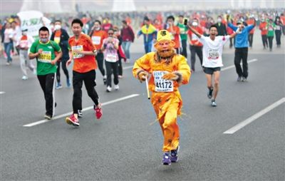 長(zhǎng)安街，一名打扮成孫悟空的參賽者在北馬隊(duì)伍里飛奔。 本版攝影/新京報(bào)記者 吳江 李飛 王嘉寧 吳江