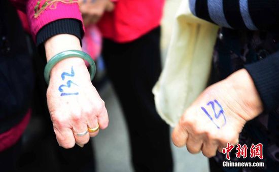 圖為10月28日，在江西九江市一家羊絨皮草服裝服飾博覽會(huì)現(xiàn)場(chǎng)，老人們正在頂著寒風(fēng)排隊(duì)等待領(lǐng)取10元代金劵。