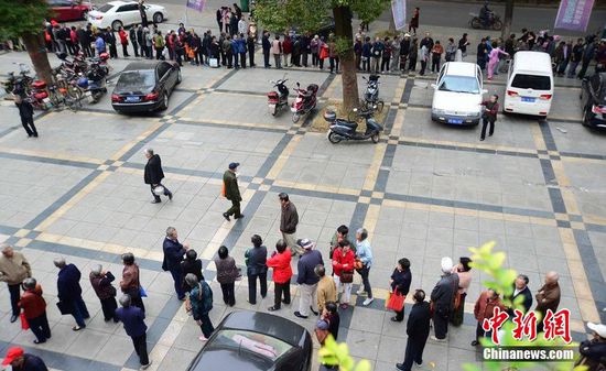圖為10月28日，在江西九江市一家羊絨皮草服裝服飾博覽會(huì)現(xiàn)場(chǎng)，老人們正在頂著寒風(fēng)排隊(duì)等待領(lǐng)取10元代金劵。