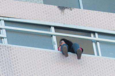 28樓的窗臺上坐著一名女子，其兩條腿耷拉在室外，不停地擺動。