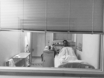 楊杰在醫(yī)院隔離病房中，沖記者揮了揮手。