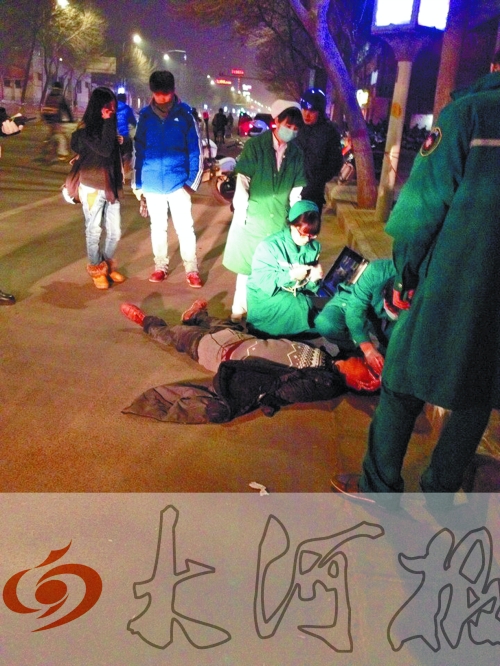 醉漢躺在地上，醫(yī)護(hù)人員對(duì)其進(jìn)行檢查。